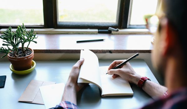 Man Writing in a Notebook