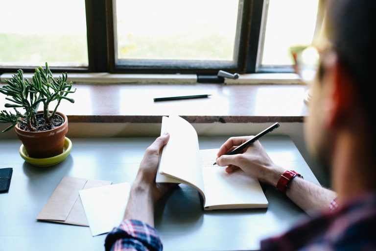 Man Writing in a Notebook