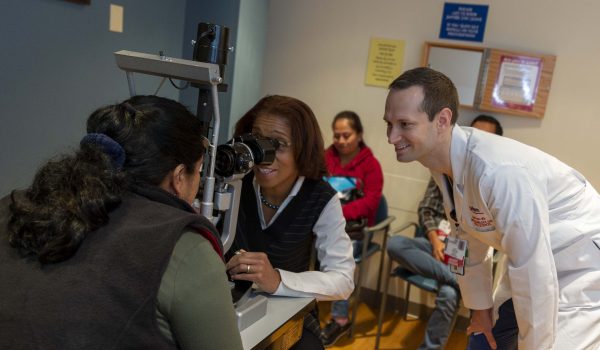 Dr. Terri Young examines patient with resident.