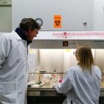 Robert Nickells, PhD, oversees a student's pipetting under the safety hood.