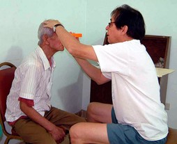 Dr. Guillermo de Venecia examines a patient's eyes