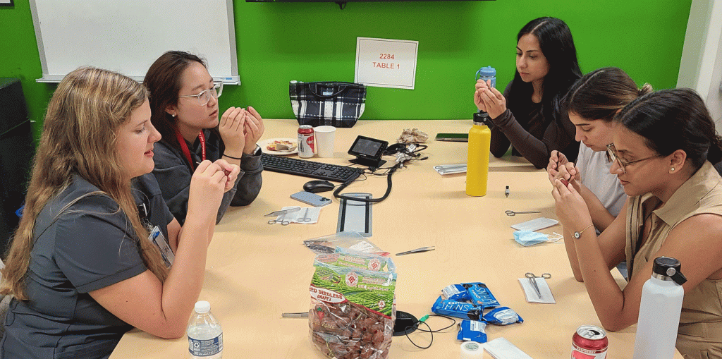 five college women use tweezers to make crafts