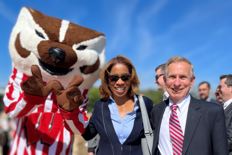 Chair Terri Young standing with Bucky Badger and Jeffrey Levy