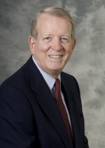 man wearing a red tie and dark suit