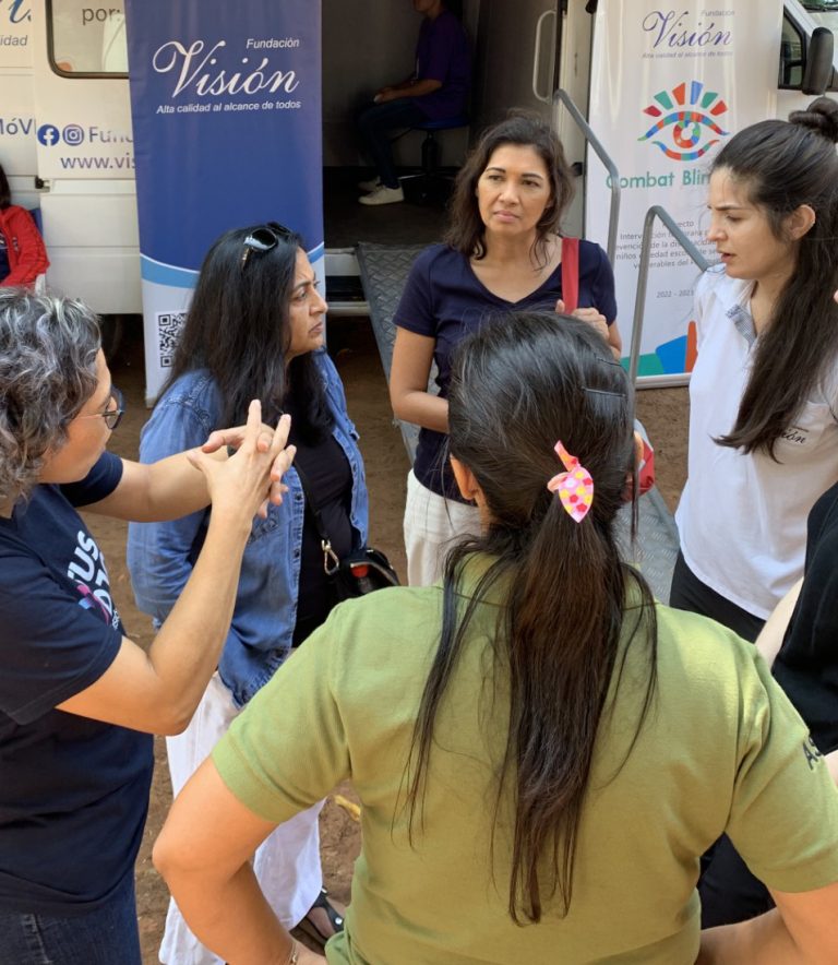 five women talk in front of a medical van