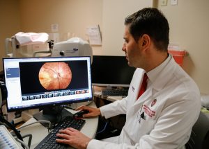Mihai Mititelu examines an enlarged photographic retina