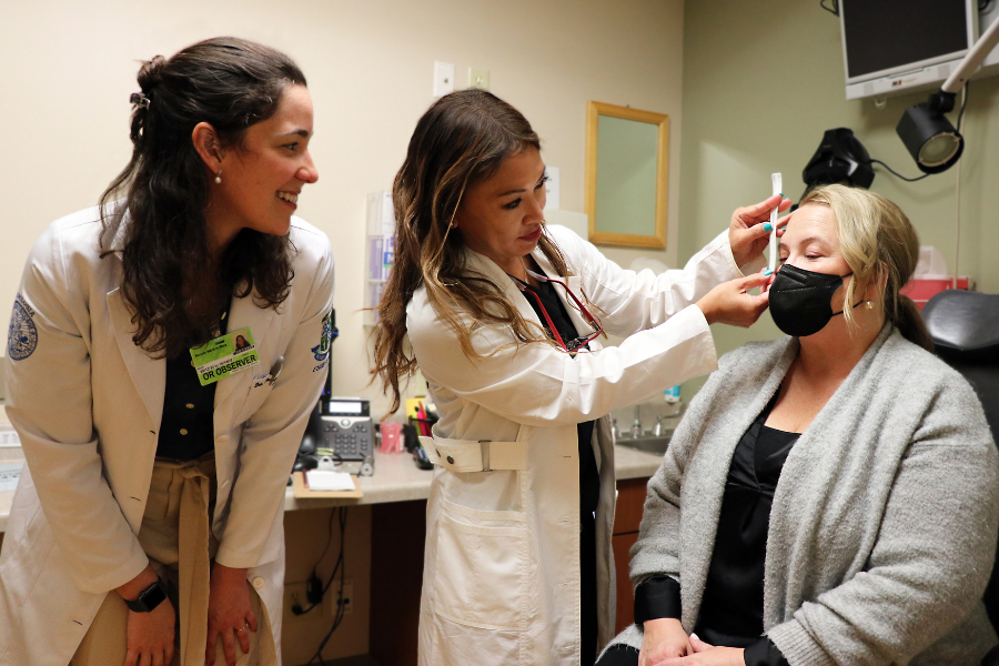 Dr. Burkat and a visiting student assist a patient.