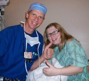 a man in surgical scrubs and a woman in glasses wearing a hospital gown