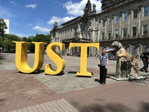 woman standing next to a UST sign