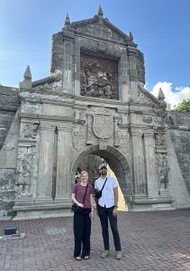 couple standing in front of a historic building