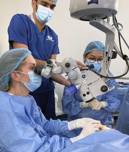 doctor in blue scrubs performing eye surgery