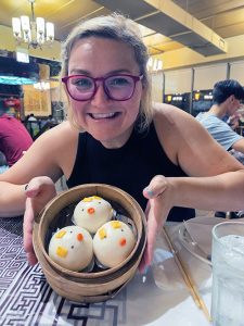 woman with glasses showing off fancy decorated steamed buns