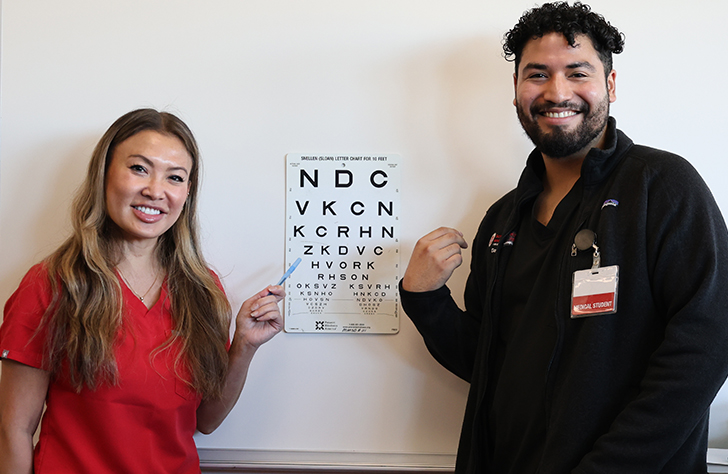 Dr. Cat Burkat and medical student by eye chart
