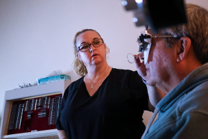 CERU's Darla Coullard measures participant's vision in a darkened room